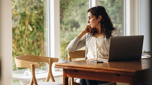 Frau mit Konzentrationsproblemen bei der Arbeit – eine der Folgen von Tinnitus.