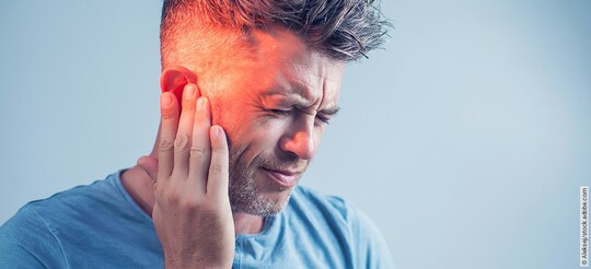 Tinnitus-Arten: Mann hält sich das Ohr.
