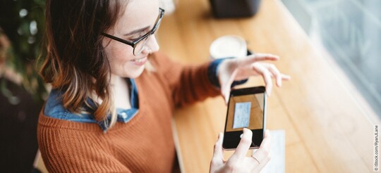 Frau scannt ein Rezept mit einem Handy