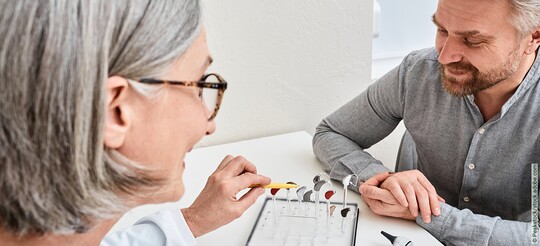Ärztin klärt ihren Patienten über ein Hörgerät bei Hörverlust mit Tinnitus auf.