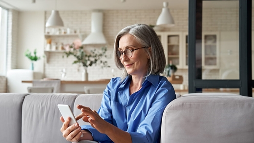 Frau nutzt auf ihrem Handy eine Tinnitus App.