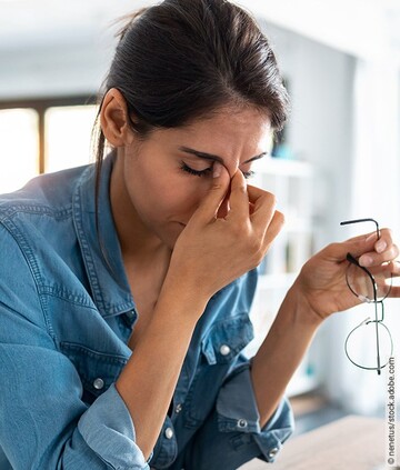 Tinnitus: Frau leidet unter Stress während der Arbeit.
