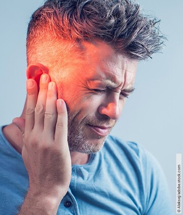 Tinnitus-Arten: Mann hält sich das Ohr.