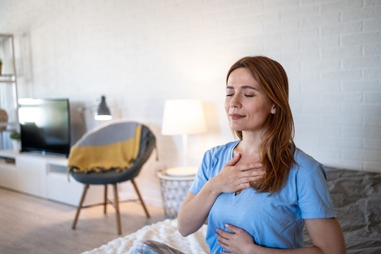 Frau unterstützt die Behandlung ihres durch Stress ausgelösten Tinnitus mit Entspannungsübungen.