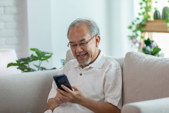 Mann nutzt sein Handy für die kognitive Verhaltenstherapie bei Tinnitus.